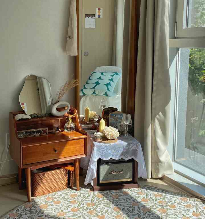 Warm-toned walk-in closet featuring wooden vanity, full-length mirror, and a Marshall speaker in a cozy setup