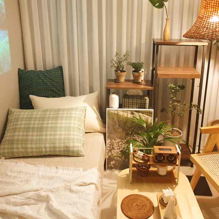 Natural modern bedroom space featuring pillows, picture frame, wood-tone shelves, and rattan chair creating cozy ambiance