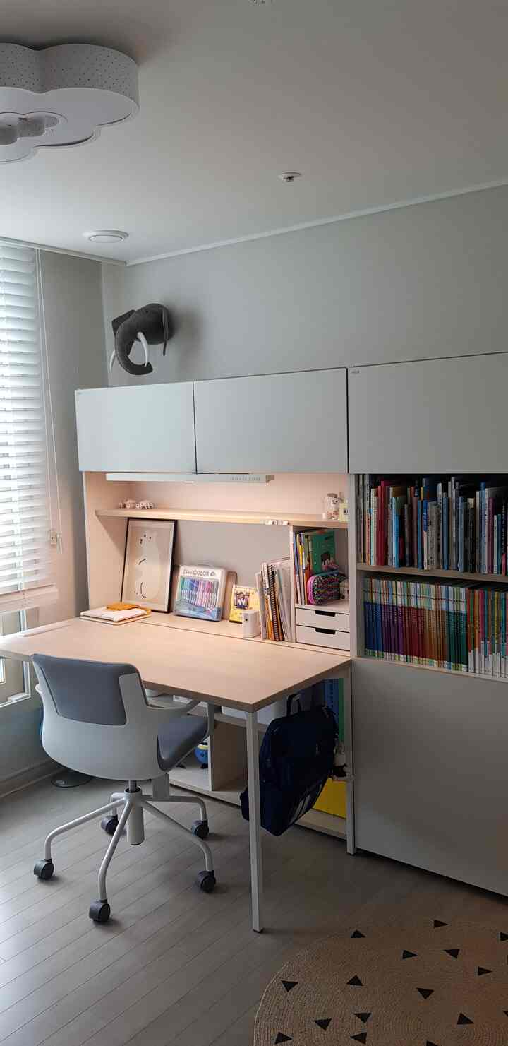 White and wood tone kids' study space featuring a desk and bookshelf with a clean, natural, and cozy atmosphere