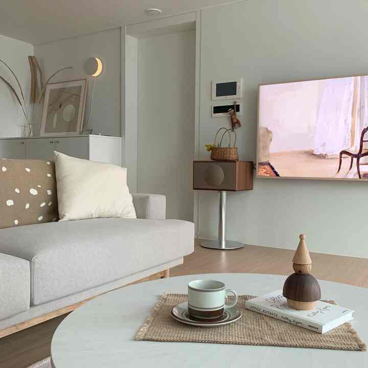 White and beige toned living room with a gray sofa and round coffee table, creating a simple and natural atmosphere