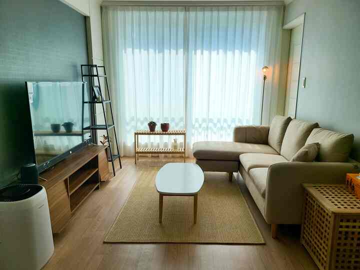 Natural-tone beige sofa and wooden furniture arranged in a bright and tidy single household living room