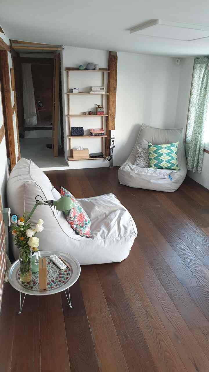 Cozy living room with natural wood tones and beige bean bag sofas in a clean, minimal setting