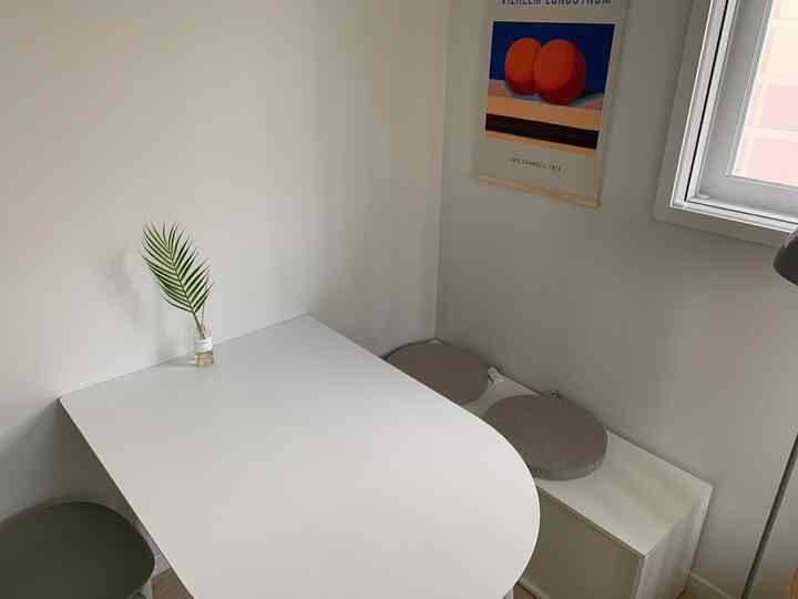 White and natural toned kitchen space featuring a dining table and bench, with a simple and clean interior atmosphere