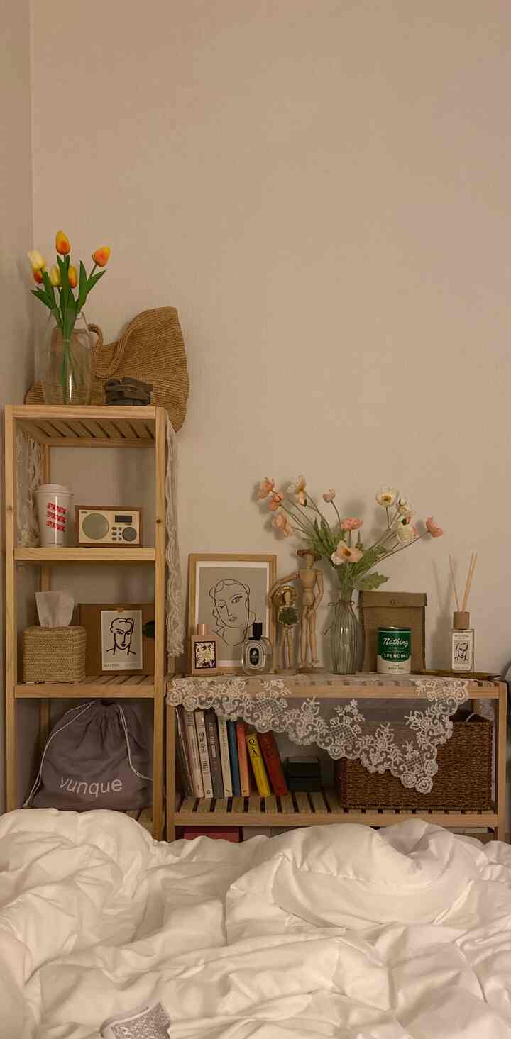 White and natural wood tone bedroom featuring shelves with decorative objects and vases creating a cozy natural atmosphere