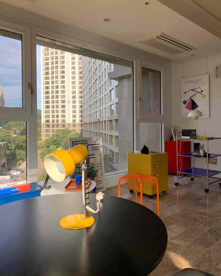 Modern living room with bright yellow lamp and colorful furniture arranged for a vibrant atmosphere