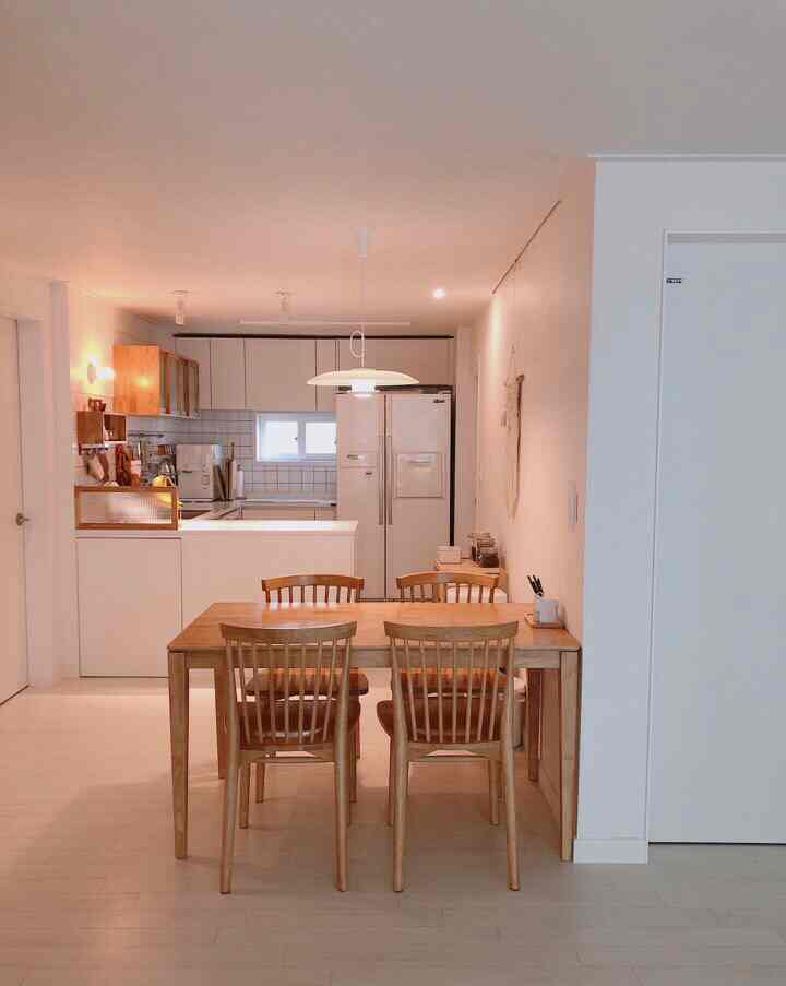 Natural wood tone with white-toned kitchen and dining table for four creating a clean, minimal space