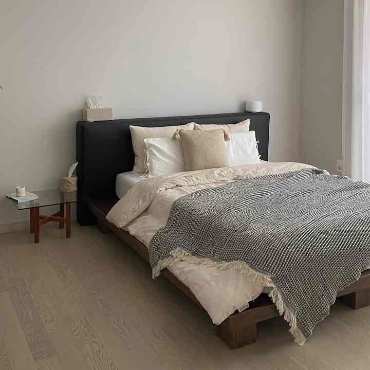 Soft beige-toned bedroom featuring oatmeal bedding and a black upholstered bed headboard creating a cozy atmosphere