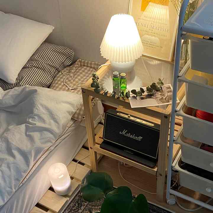 ホワイトとウッドトーンのワンルーム寝室、ムードライトとマーシャルスピーカーが配置された雰囲気のある癒しの空間