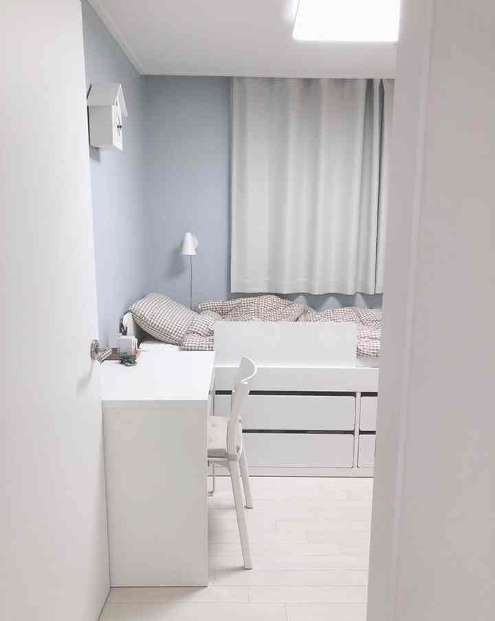 白と淡い青の子供部屋、ベッドと収納付きのデスクが配置されたシンプルモダンな印象的な空間