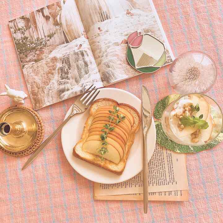 Pink-toned dining space featuring a checkered tablecloth with toast and yogurt, creating a cozy home cafe setup