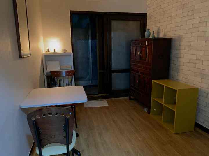 Natural-toned compact dining room with simple white table and wooden chairs creating a cozy atmosphere