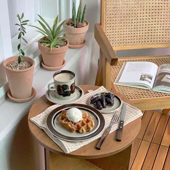 Wood tone veranda space featuring a rattan chair and side table with home cafe desserts, creating a cozy atmosphere