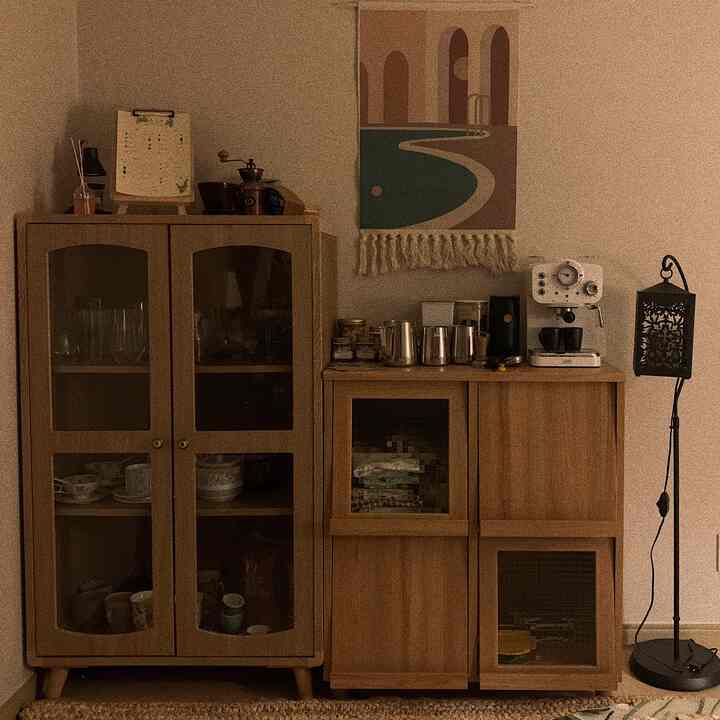 A cozy home cafe space in beige and brown wood tones featuring storage cabinets and a coffee machine