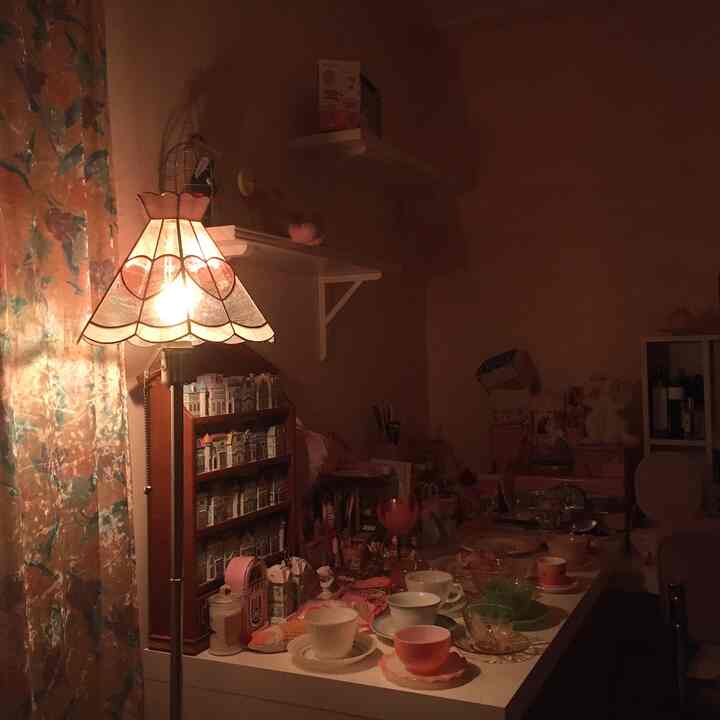 Warm orange-lit vintage-style home cafe featuring teacups and decorative items on a cozy table