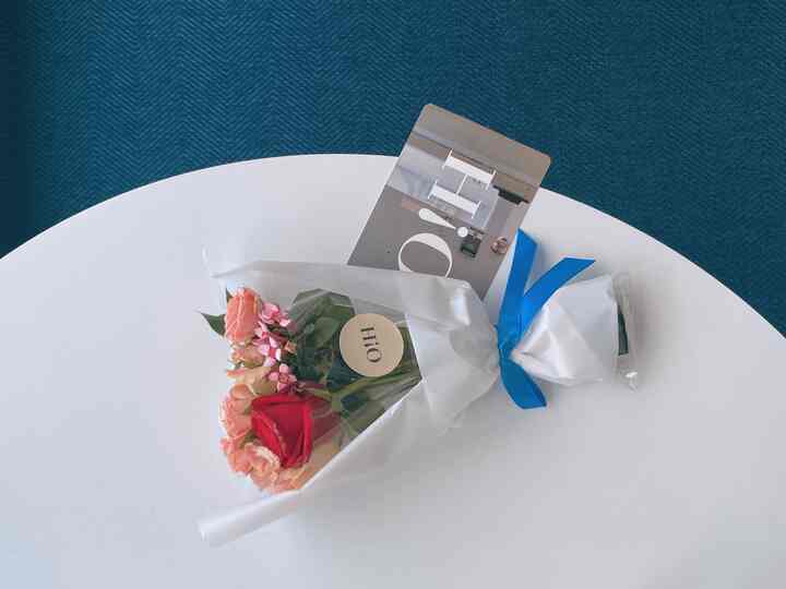 Simple interior with white round table and bouquet on a navy rug background