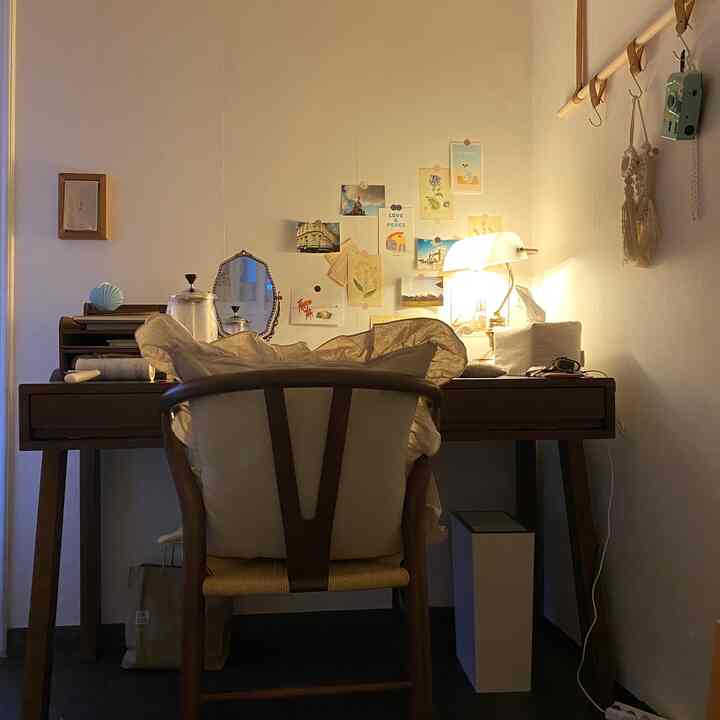 Natural-toned home office space featuring a wooden desk and armchair, warm lighting creating a cozy atmosphere