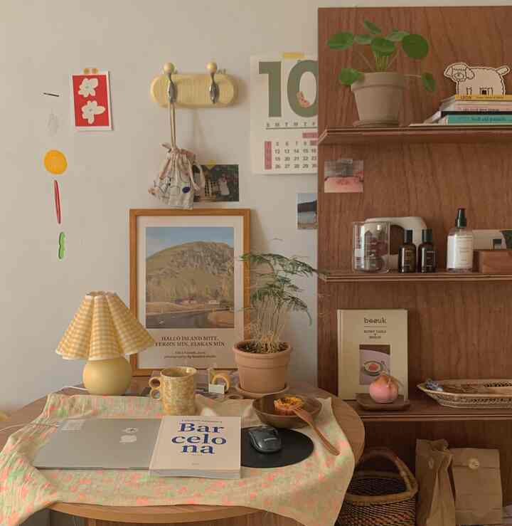 A cozy, warm home cafe space with natural wood shelves and plants in a small room featuring a wooden table