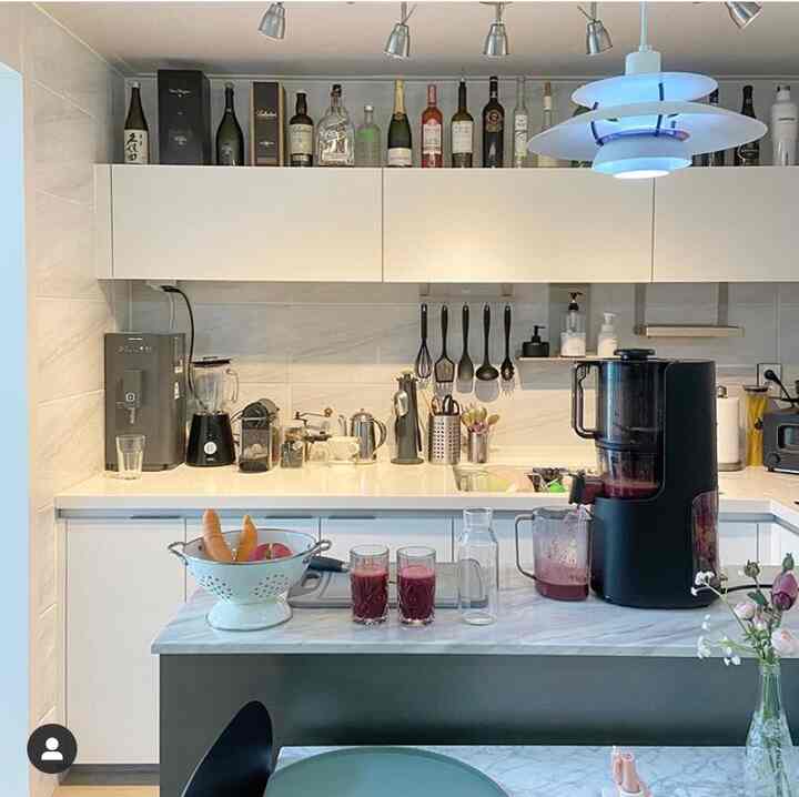 White and black toned kitchen featuring pendant lighting, Hurom juicer, and kitchen utensils with a clean modern atmosphere