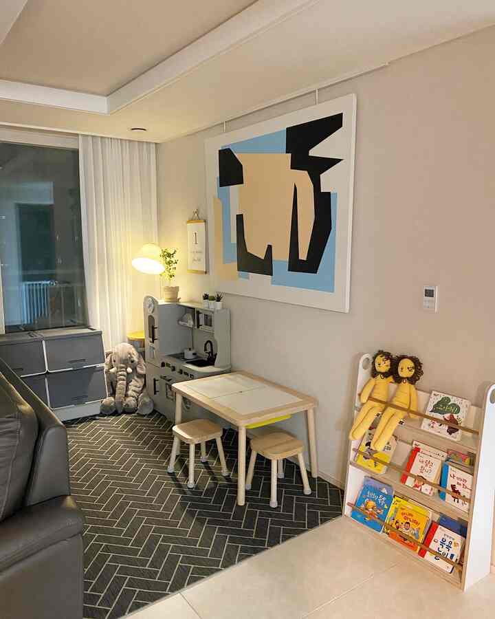 Natural-toned kids' room featuring wooden table and stools, an elephant plush toy, and a herringbone patterned rug creating a cozy atmosphere
