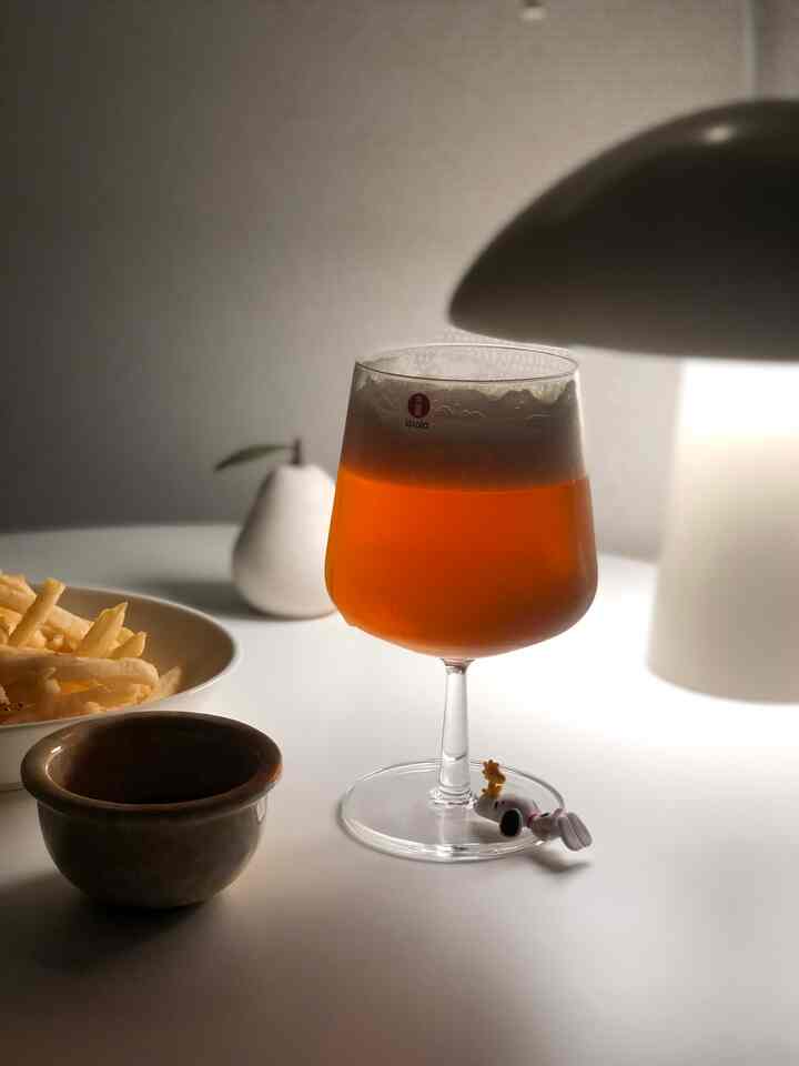 ホワイトトーンの寝室、テーブルランプとビールグラス、皿が配置された雰囲気のあるホームバー空間