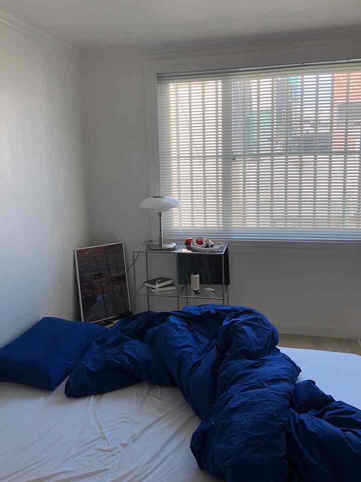 Cozy white bedroom featuring metal modular furniture and blue accent bedding