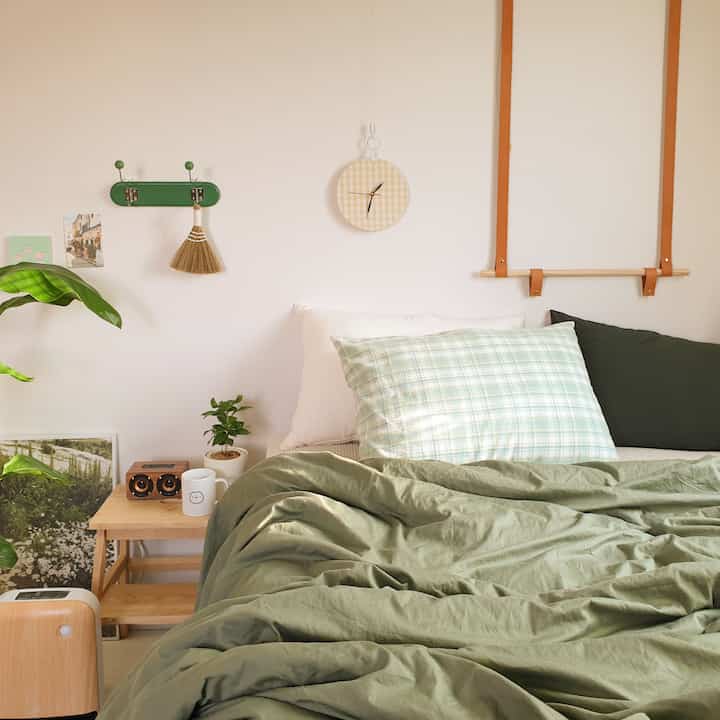 Peaceful bedroom with green bedding and natural element decor