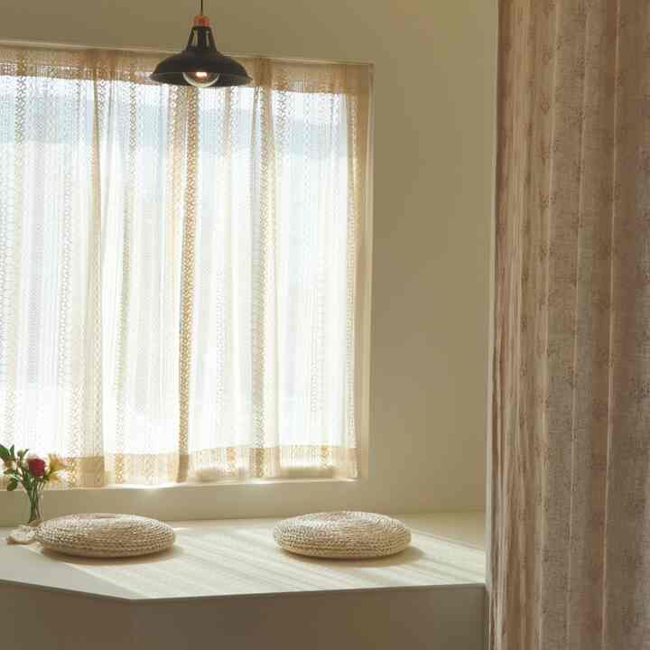 Beige and ivory toned living room featuring rattan cushions and a vase, creating a natural atmosphere
