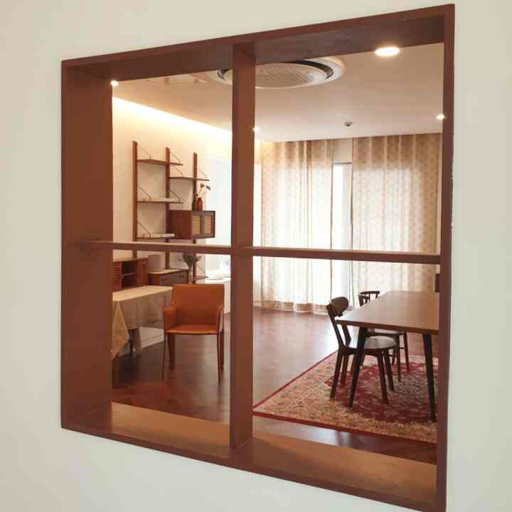 暖かい木目調のリビングルーム、4人用ダイニングテーブルとアームチェア、ヴィンテージのペルシャ絨毯が配置された空間