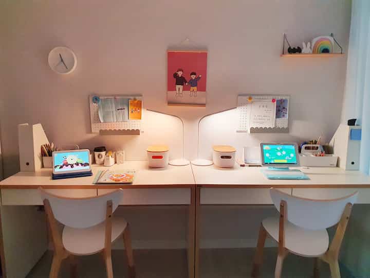 White and wood-tone two-person kids' study room featuring desks and chairs arranged side by side with a clean study environment