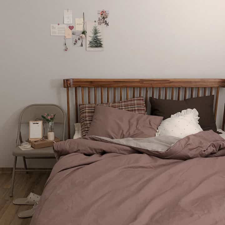 Warm brown and wood tone bedroom featuring checkered pillows and cozy bedding in a calm atmosphere