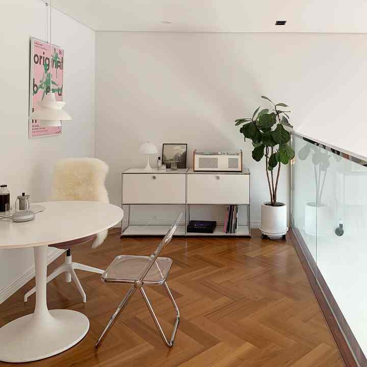 Modern single household home office with white walls and brown herringbone wooden floor