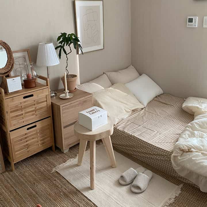 Beige and wood-tone studio bedroom featuring natural accessories and cozy bedding with a warm and inviting atmosphere