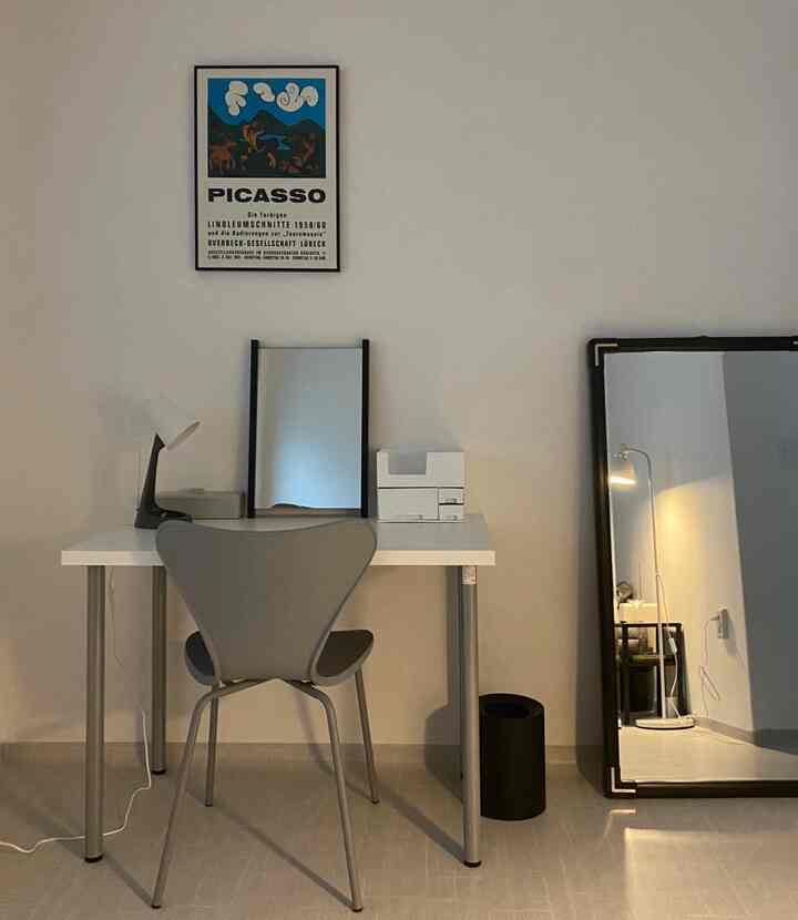 Charcoal and gray toned home office space with simple desk and chair in modern interior