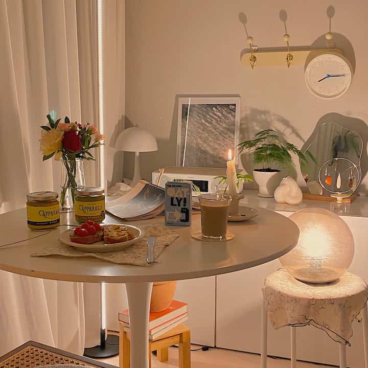 Warm natural-toned living room featuring a round table and table lamp creating a cozy atmosphere