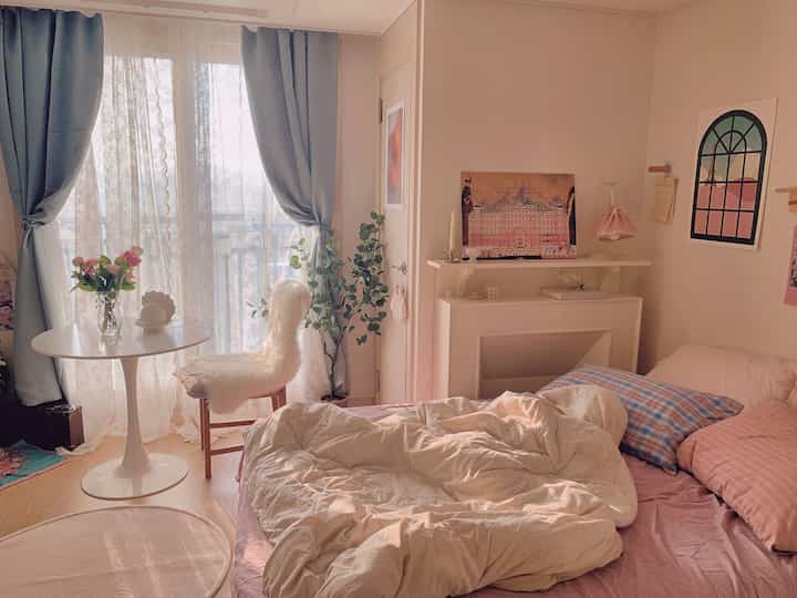 Cozy natural-toned bedroom featuring a round table and pillows, creating a warm winter atmosphere