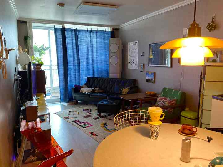 Living room with blue curtains and black sofa, cozy home cafe atmosphere featuring warm lighting and decor