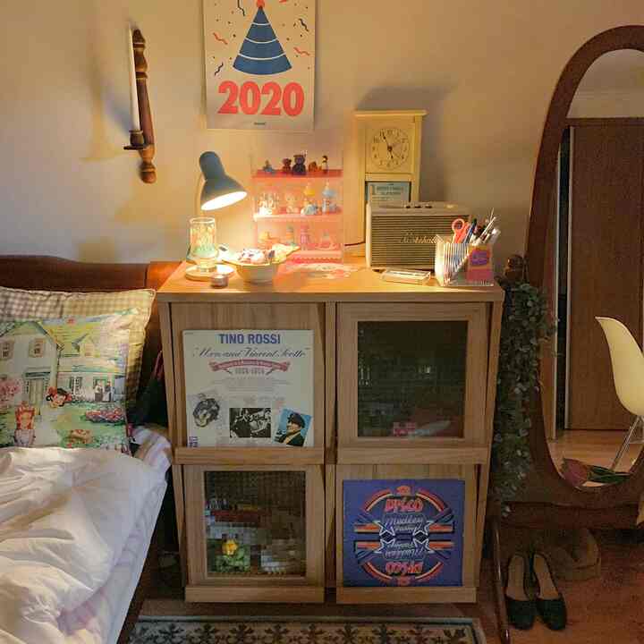 Light brown wooden cabinet and bed in a natural-toned bedroom featuring vintage decor for a cozy atmosphere