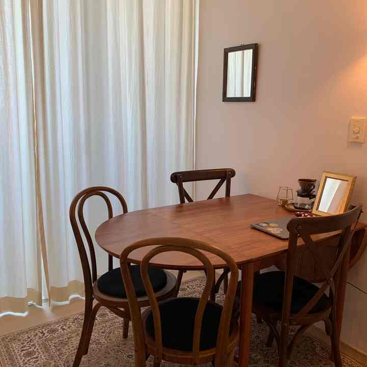 Natural-toned dining room featuring wooden dining table and chairs with cozy home cafe elements