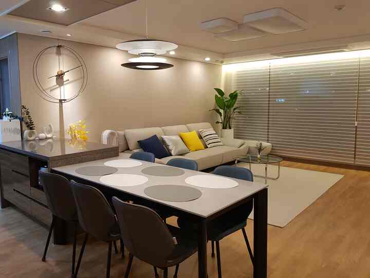 ウッドトーンとモダンスタイルのリビング・ダイニングルーム、ネイビーのダイニングチェアと明るいトーンのソファが調和する雰囲気のあるインテリア