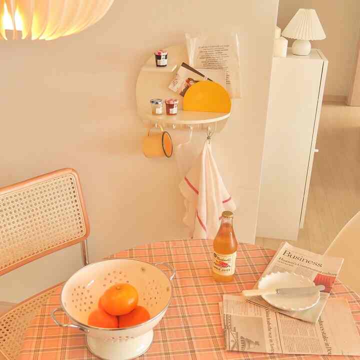 ベージュ調のキッチン空間、丸テーブルとラタンチェア、壁に丸い棚が配置された雰囲気のあるおうちカフェ