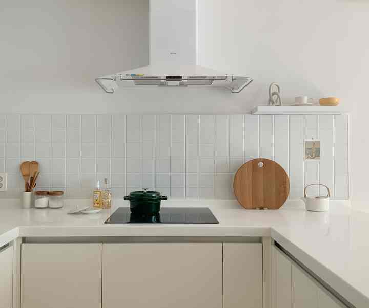 White and wood tone kitchen without upper cabinets featuring clean and minimalist design