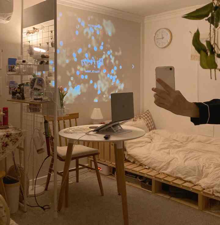 Cozy small bedroom in white and beige natural tones featuring a wooden pallet bed and round table