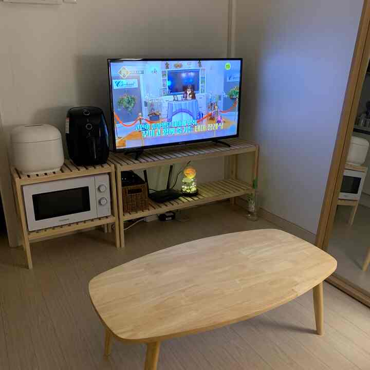 Natural wood tone compact living room featuring a TV stand and coffee table with cozy atmosphere