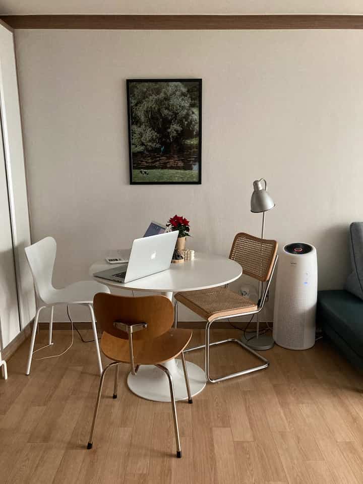 White and brown toned living room featuring a round dining table and assorted chairs with a practical, open atmosphere