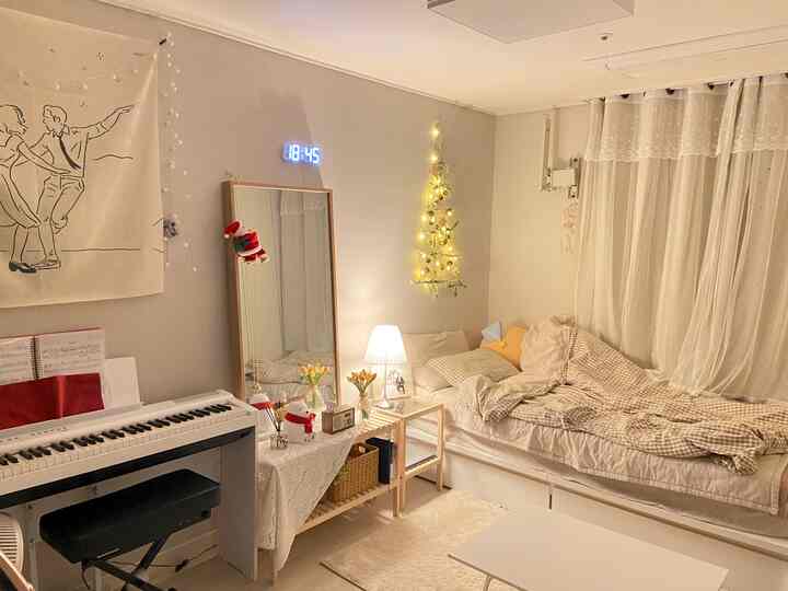 Cozy small bedroom in warm beige and white tones featuring a single bed, wooden furniture, curtains, and soft ambient lighting