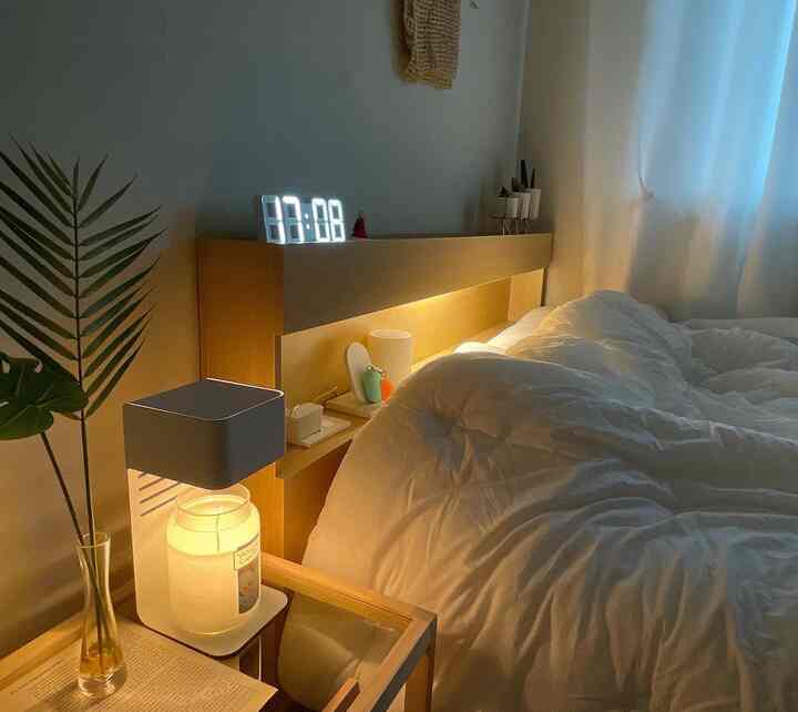 Wood tone and white bedroom featuring a bed with headboard and warm lighting creating a cozy atmosphere