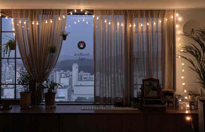 Beige-toned living room featuring linen curtains and soft string lights with a natural atmosphere