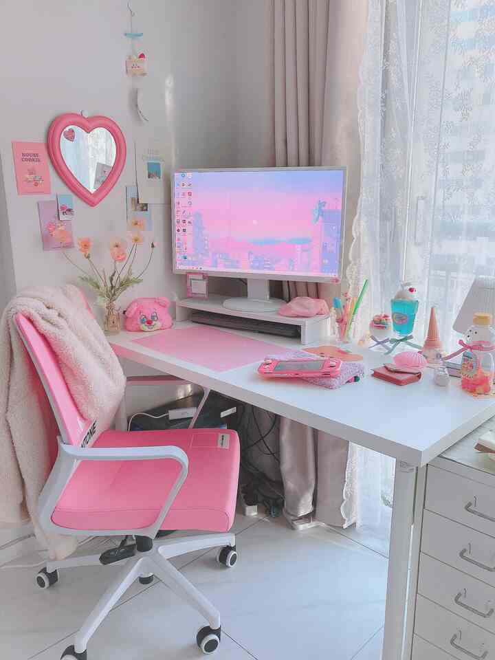 Pink and white toned single room home office featuring a gaming chair and desk in a cozy workspace
