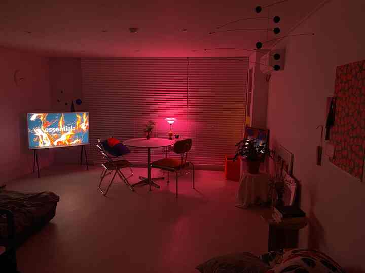 Dining room with pink table lamp and round table, modern-style living space with clean lines and ambient lighting