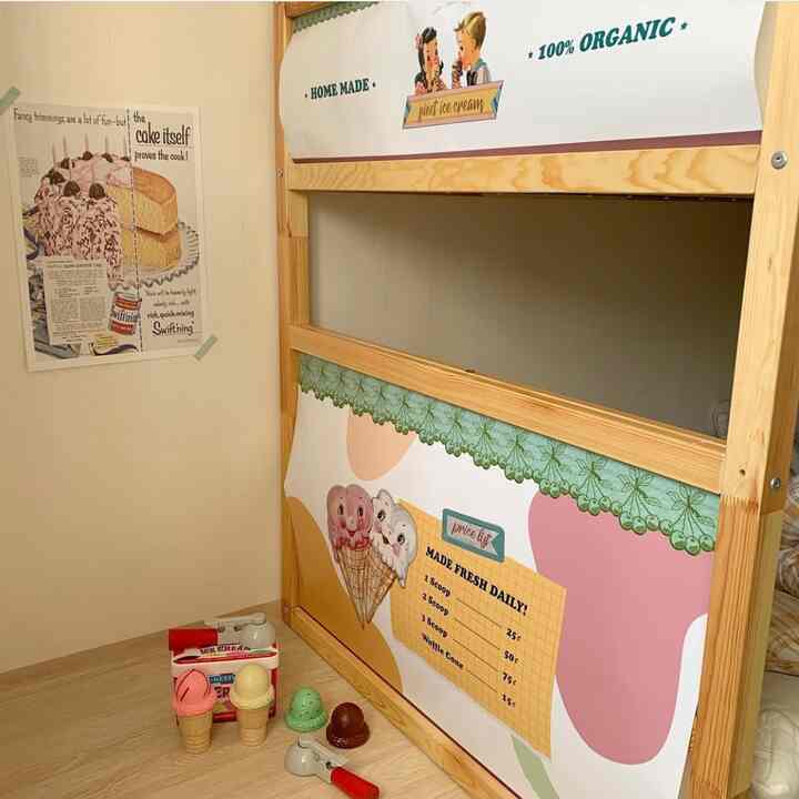 Beige walls and natural wood IKEA KURA bed transformed into an ice cream shop play area in a baby’s room